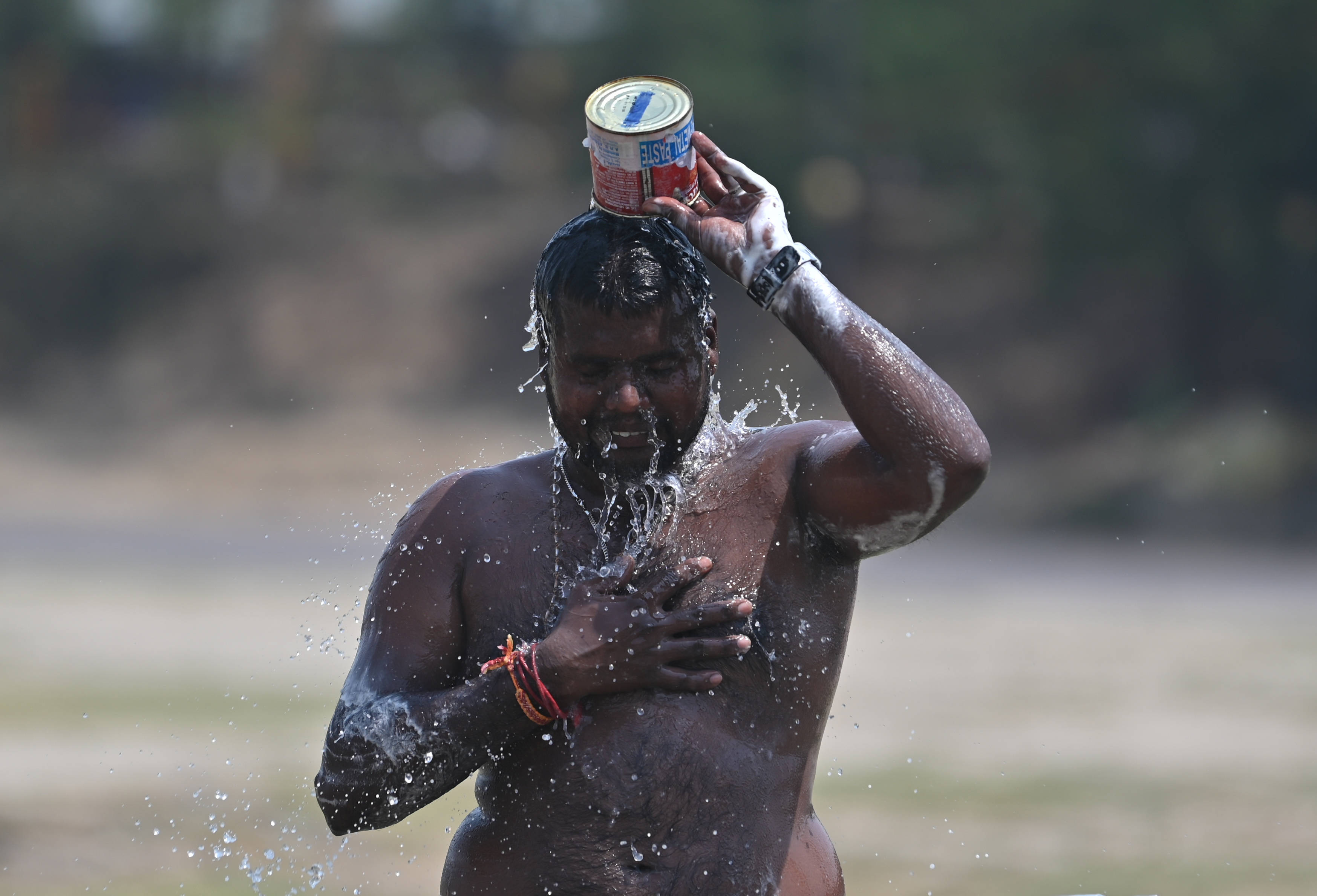 Ein Mann in Indien überschüttet sich mit Wasser
