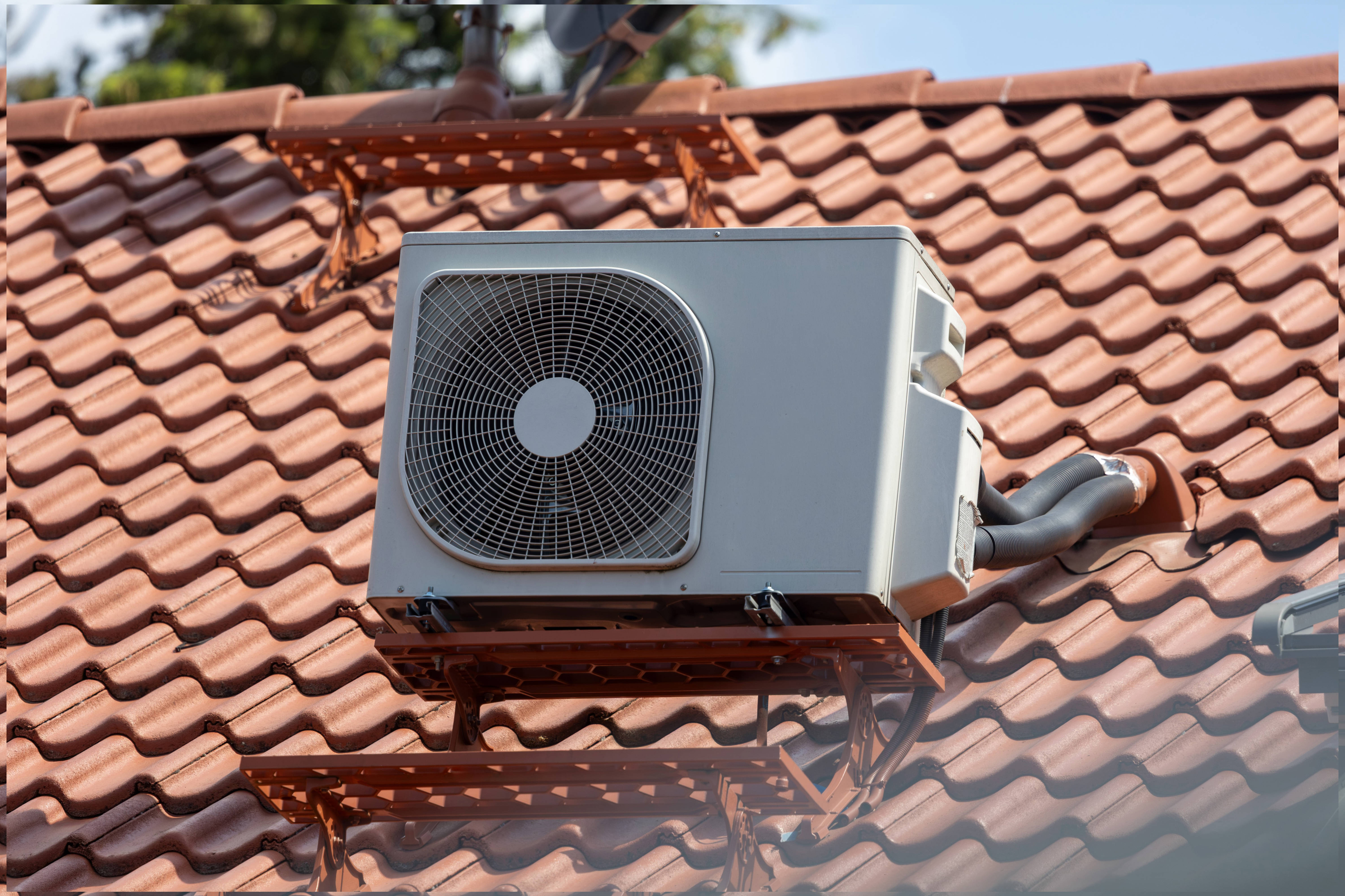 Klimaanlage Außengerät auf dem Ziegeldach eines Einfamilienhauses