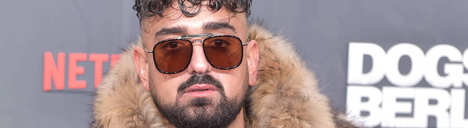 Rapper Haftbefehl im Pelzmantel bei der Weltpremiere von Dogs Of Berlin