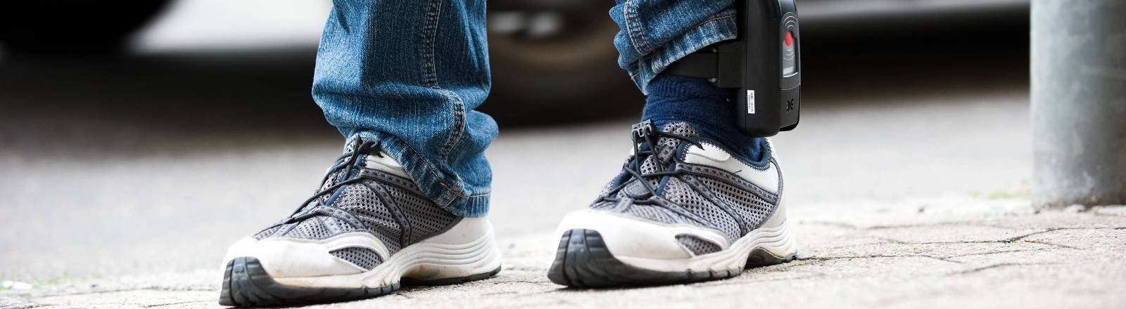 Elektronische Fußfessel am linken Knöchel eines Beins