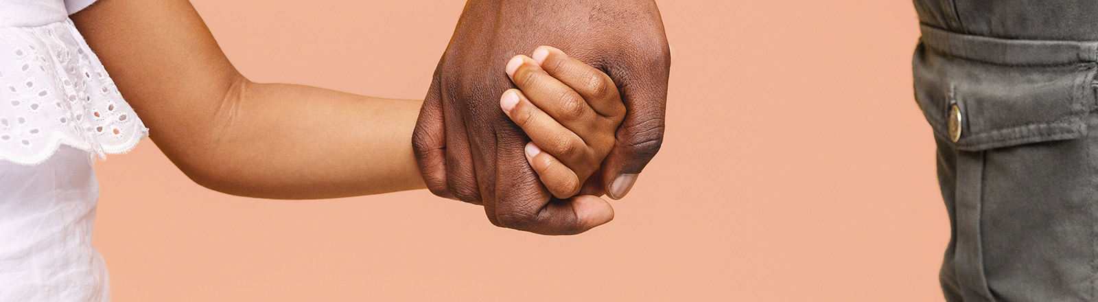 Nahaufnahme der Hand eines Mannes, der das Hand eines Kindes hält