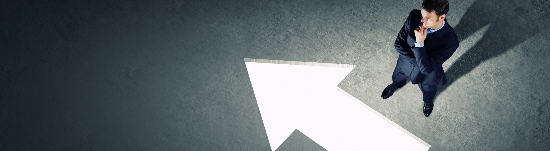 Mann in Anzug überlegt ob er einem Pfeil folgen soll