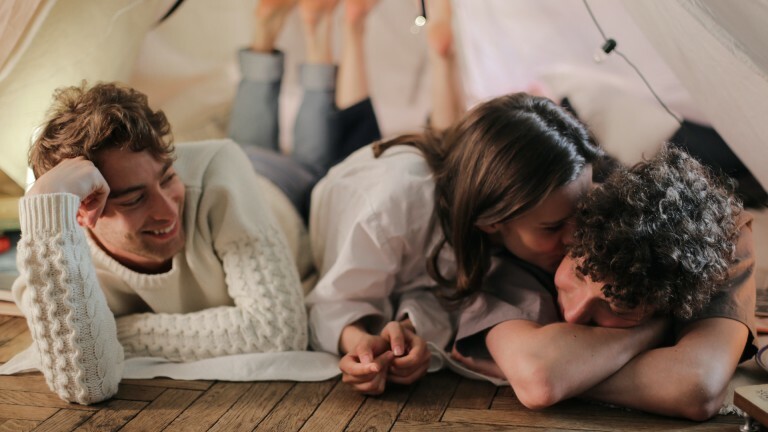 Zwei Männer und eine Frauen liegen auf dem Boden