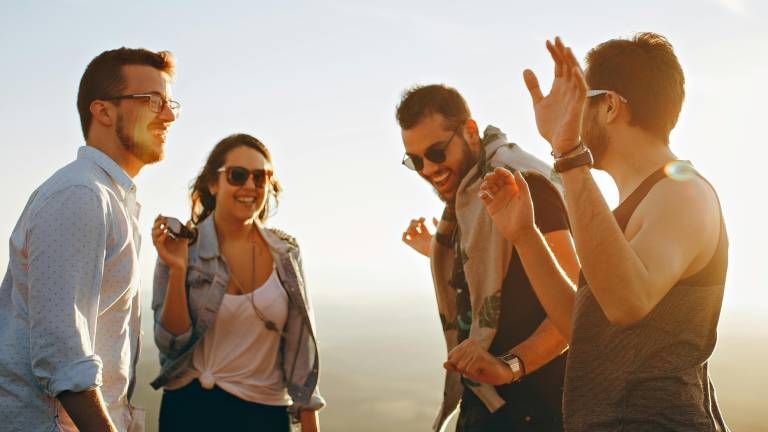 Mehrere Leute stehen zusammen und lachen miteinander.
