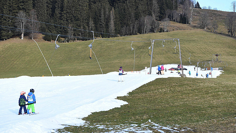 Wintersportler fahren am 31.12.2022 im Skigebiet Salzburger Land über die Piste. Viele Skigebiete in Österreich leider aktuell unter Schneemangel.