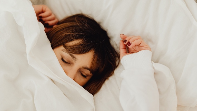 Eine Frau liegt im Bett und schläft
