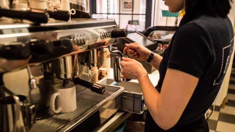 Eine Frau an der Kaffeemaschine