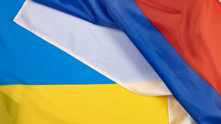 Die Flaggen von Russland und der Ukraine liegen übereinander.