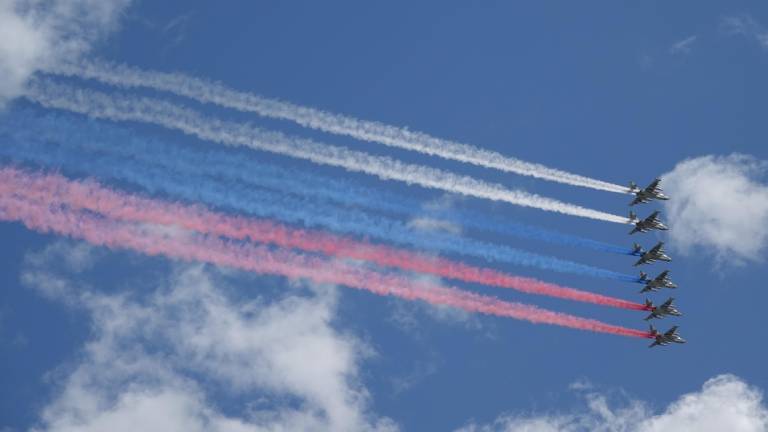 Die russischen Luftstreitkräfte fliegen bei der Militärparade über den Roten Platz und bilden mit farbigen Raum die russische Staatsflagge.