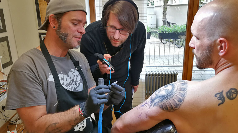 Deutschlandfunk-Nova-Reporter Sebastian Sonntag bei Tätowierer Peter Epping, der gerade ein Tattoo sticht