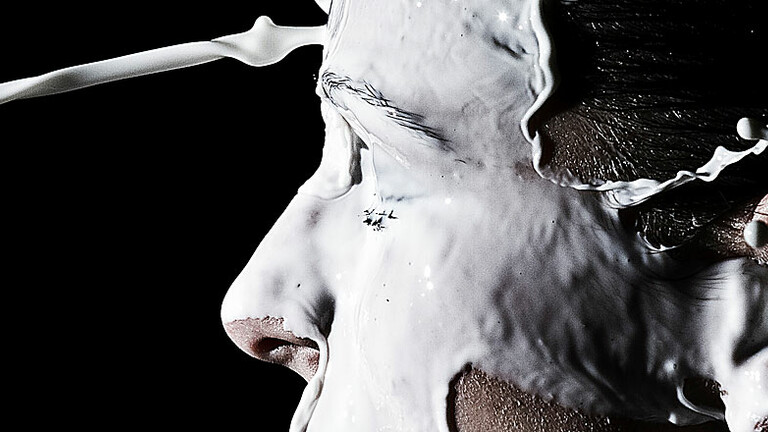 Ein Milch-Strahl klatscht einem Mann ins Gesicht