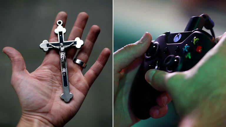 Ein Gamer bedient eine Spielekonsole. Auf einer ausgestreckten Hand liegt ein Kreuz.