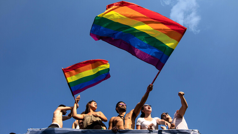 Christopher-Street-Parade in Berlin 2018: Männer und Frauen auf einem Truck mit Regenbogenflaggen.
