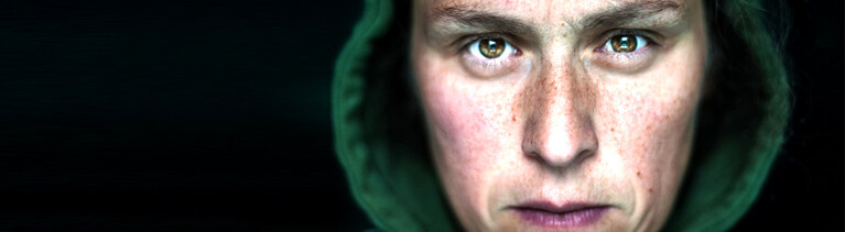 Eine Person im Hoodie mit entschlossenem Blick