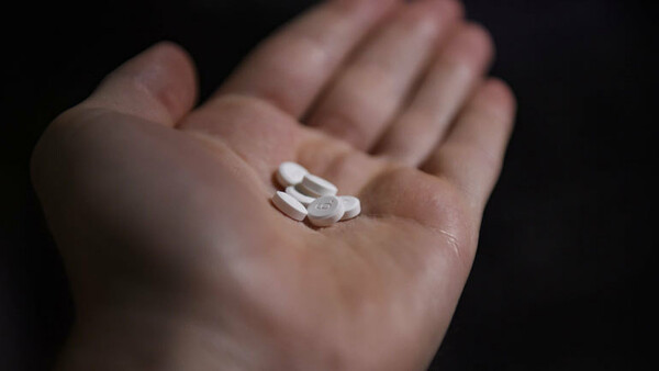 Eine geöffnete Hand - darin liegen Tabletten.