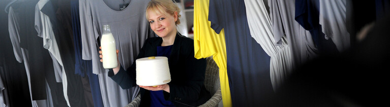 Die Modedesignerin und Biochemikerin Anke Domaske posiert am 19.09.2011 in Hannover mit einer Milchflasche, aus Milchfasern versponnenes Garn und daraus hergestellten Kleid.