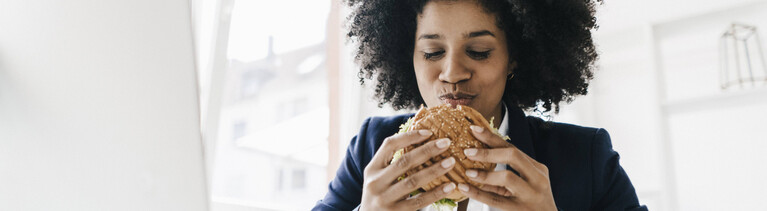 Eine Frau isst einen Burger.