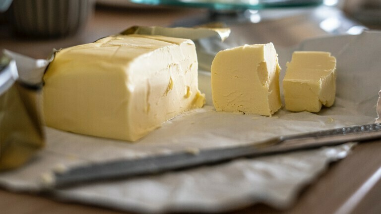 Eine geöffnete Packung Butter liegt auf einem Tisch.