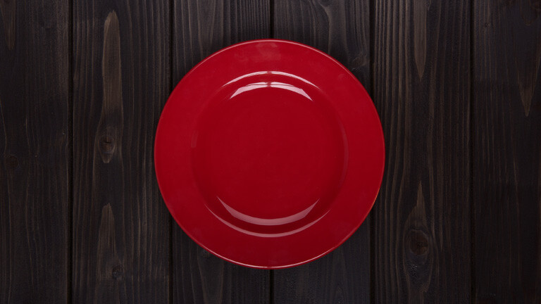 Roter Teller auf Holztisch