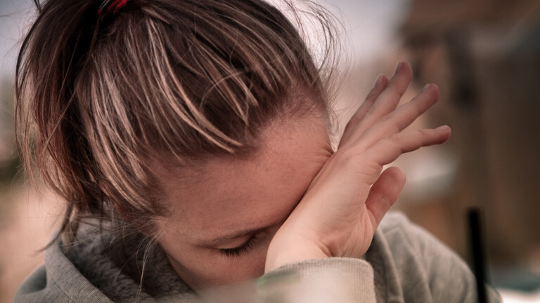 Frau stützt Kopf mit der Hand