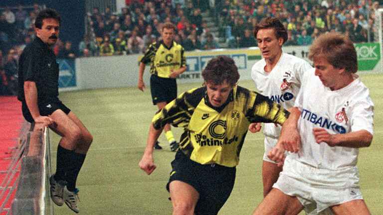 Manfred Führer als Schiedsrichter, flüchtet sich bei einem Bundesliga-Spiel auf die Bande.