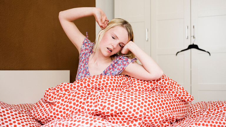 Frau im Bett, die sich räkelt