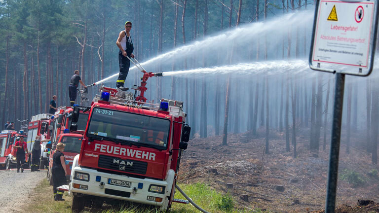 In Mecklenburg-Vorpommern löschen Feuerwehrleute in der Nähe der evakuierten Ortschaft Alt Jabel einen großflächigen Waldbrand; Foto: dpa