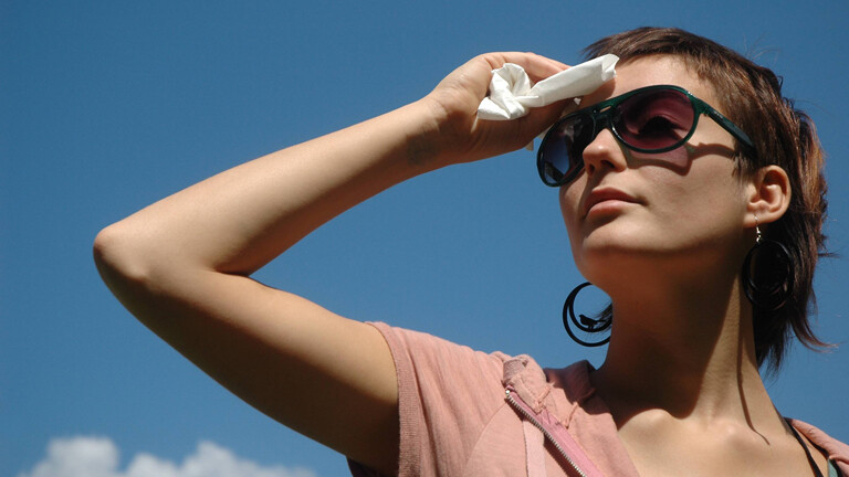 Junge schwitzende Frau mit Sonnenbrille.
