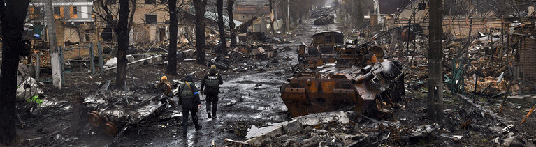 Auf einer Straße liegen verbrannte Autos, die Häuser sind zerstört; Szene aus einem Vorort von Kiew am 3. April 2022.