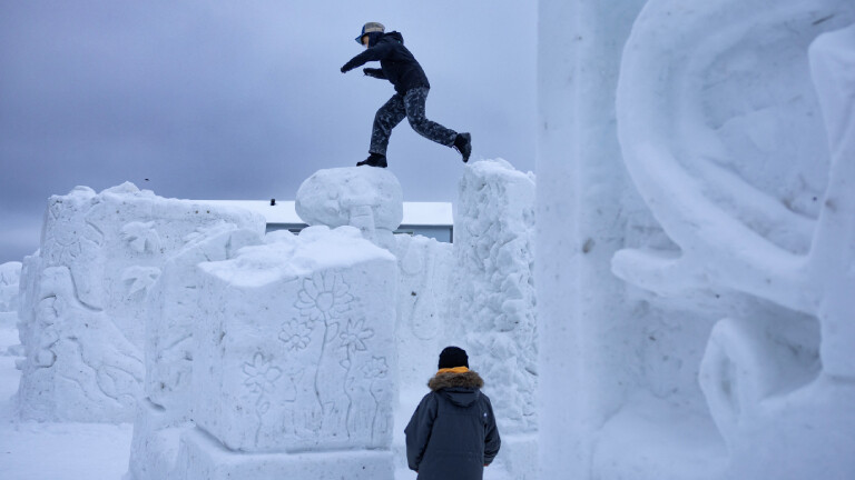 Spielende Jugendliche auf Eisskulpturen in Grönland