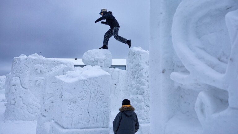 Spielende Jugendliche auf Eisskulpturen in Grönland