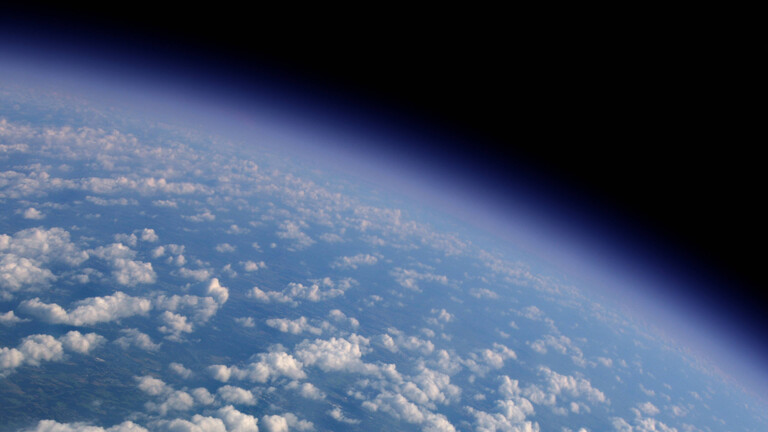 Fotografie eines Teiles der Erde aus dem Weltall mit blauem Meer und darüber weißen Wölkchen