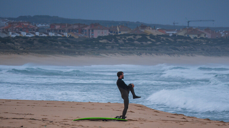 Ein Surfer dehnt sich am Strand