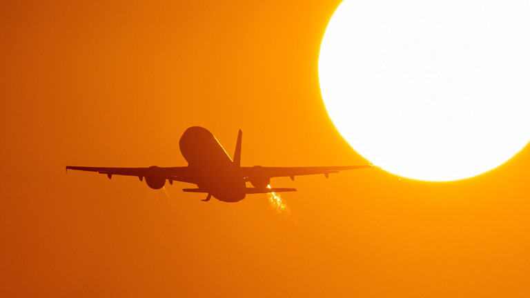 Ein Flugzeug startet bei Sonnenaufgang am Flughafen Düsseldorf.