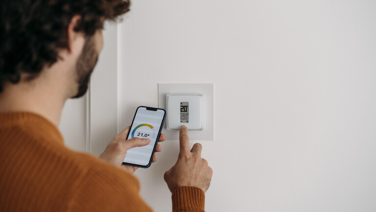 Ein Mann stellt seine Heizung per App ein