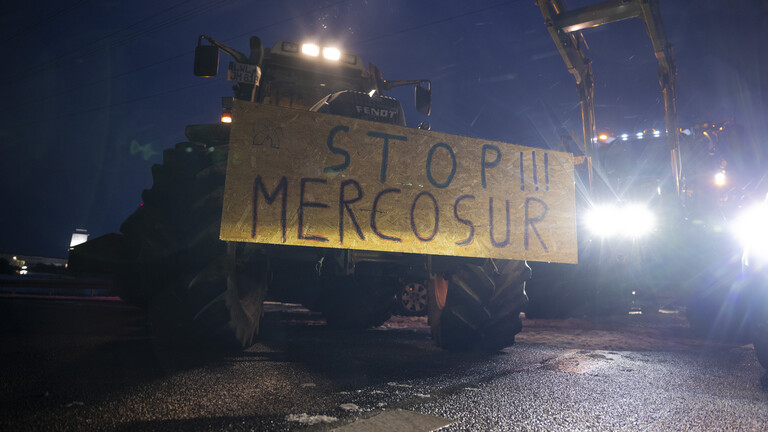 Ein Schild mit der Aufschrift "Stopp!!! Mercosur" ist an einem Traktor befestigt.