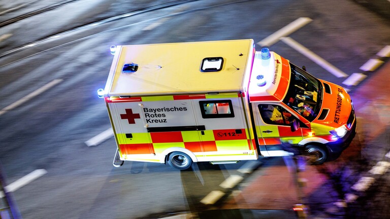 Ein Krankenwagen vom Bayerischen Roten Kreuz mit eingeschaltetem Blaulicht.