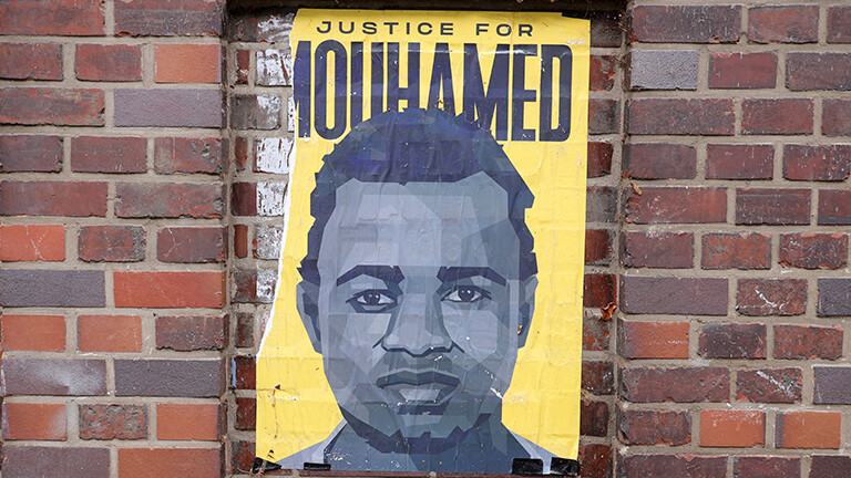 Plakat mit dem Gesicht von Mouhamed Drame