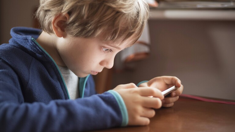 Junge, der aus kurzer Entfernung auf sein Smartphone schaut