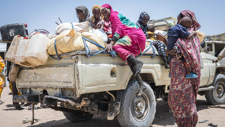 Sudanesische Flüchtlinge sitzen auf einem vollbepackten Auto