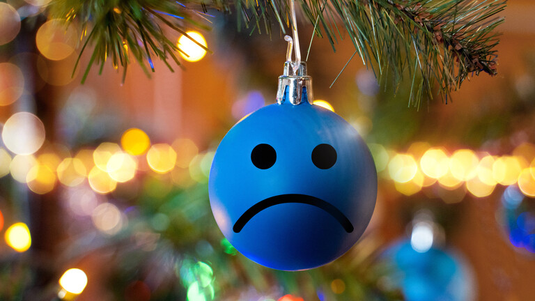 Weihnachtskugel mit traurigem Emoji-Gesicht