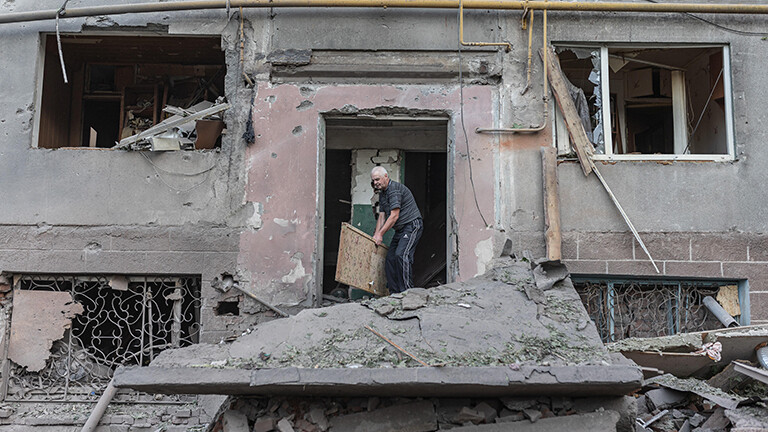 Ein Mann in der Ukraine räumt Kriegs-Trümmer weg