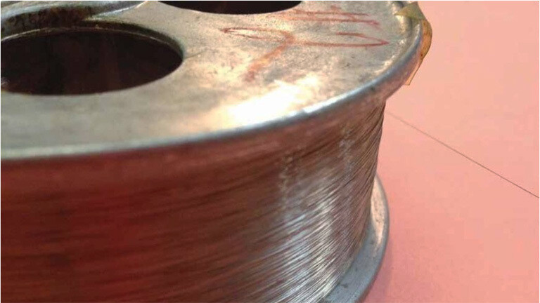 Eine Spule von etwa acht Zentimeter Durchmesser ist mir einem Karbon-Stahldraht umwickelt.