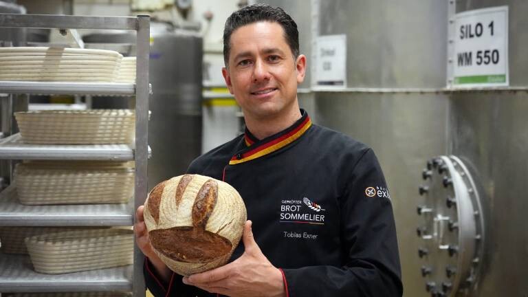 Bäckermeister Tobias Exner hält ein Brot in der Hand