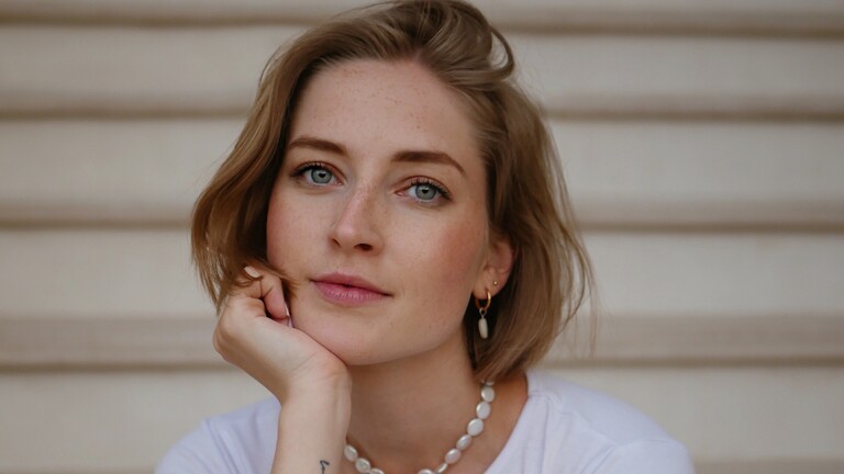 Ein Portrait von Laura, die in die Kamera blickt