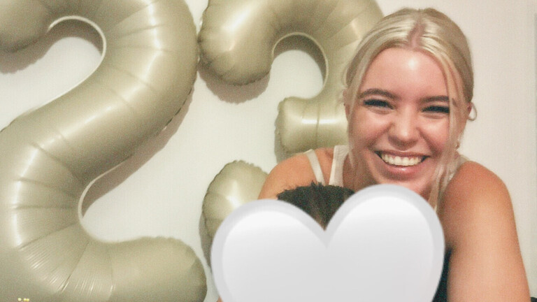 Lea lacht in die Kamera, hinter ihr die Zahl 23 als großer Luftballon