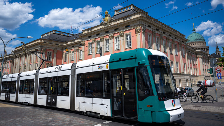Eine Straßenbahn in Potsdam vor einem Schloss