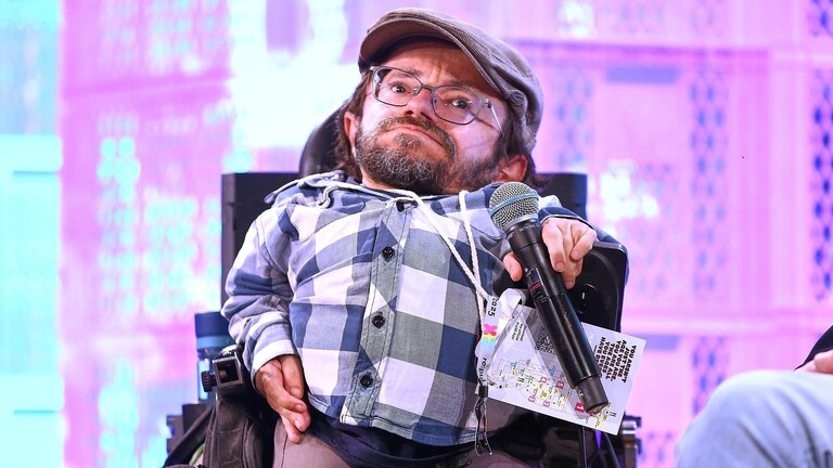 Raúl Krauthausen mit Mikrofon im Rollstuhl