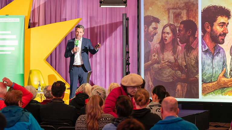 Der Informatiker Tim Landgraf hält seinen Vortrag "Vom Bienenstock zu Skynet: Wie KI unsere kollektive Intelligenz verändert" für den Deutschlandfunk-Nova-Podcast 'Hörsaal' im Rahmen des Silbersalz Science & Media Festivals 2025.