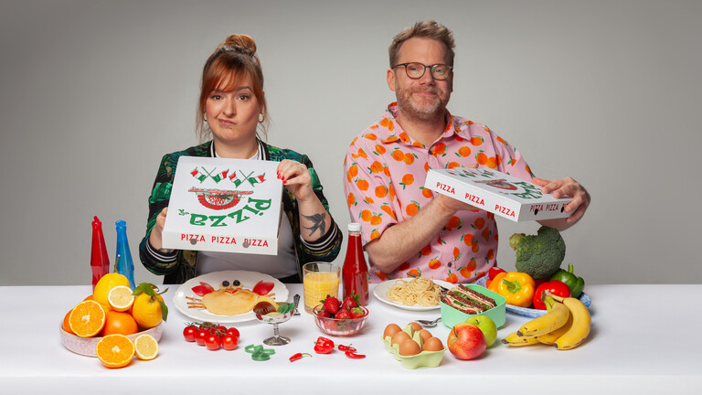 Julia Floß und Christian Schmitt an einem Tisch mit bunten Lebensmitteln